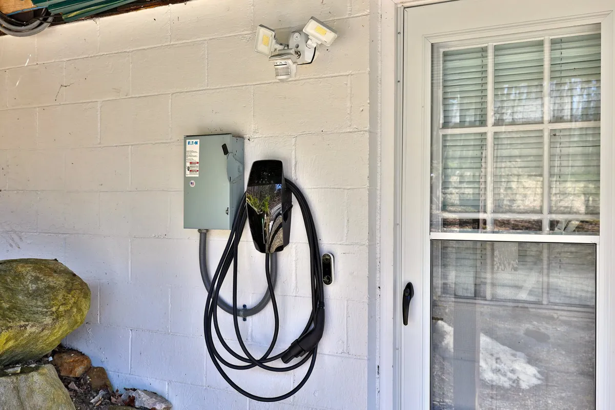Captured here is an electric vehicle charging station near the home’s exterior, blending eco-friendly convenience with outdoor utility. The charger’s location offers practical accessibility for guests with EVs.