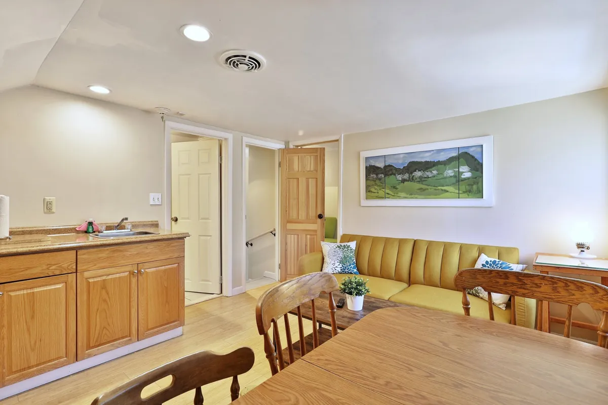 A homey kitchenette with a comfortable seating area, wall art, and an open layout that encourages shared meals, conversation, and celebration.